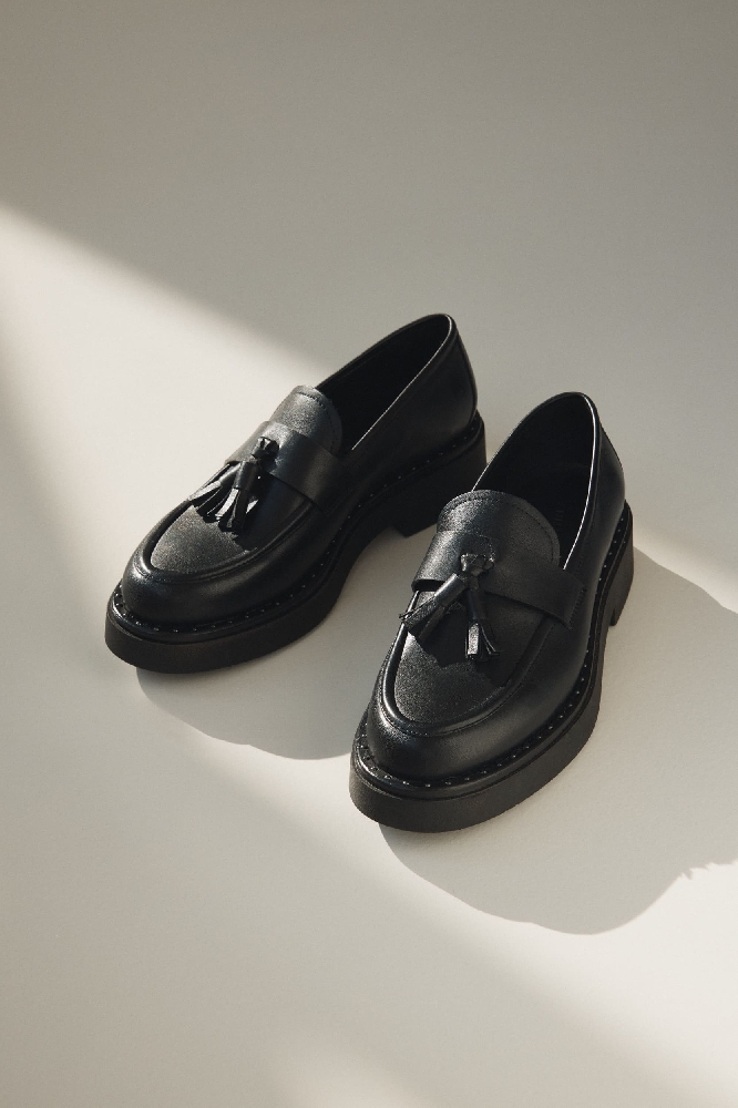  mocasini negri pe fundal bej